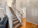 Bright staircase with carpeted steps, white railings, and hardwood floors on the landing at 3229 Leicester Dr, Matthews, NC 28104