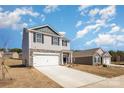 Desirable two-story home featuring a stone facade, attached garage, and green landscaping under blue skies at 3309 Colorado Blue Ct, Gastonia, NC 28056