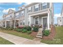 Charming townhome with grey siding, a covered front porch, and mature landscaping at 4102 Harmony Hills Dr, Matthews, NC 28104