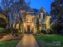 Elegant home featuring a grand entrance, lush landscaping, and a welcoming brick pathway at 4510 Old Course Dr, Charlotte, NC 28277