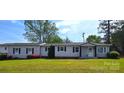 Single-story home featuring gray siding, black shutters and a well-kept lawn at 4790 Polk Ford Rd, Stanfield, NC 28163