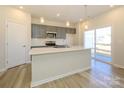 Modern kitchen featuring a large island, stainless steel appliances, gray cabinetry, and stylish pendant lighting at 8021 Lerwick Trl, Charlotte, NC 28269