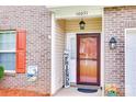 Inviting entryway with stylish door, sidelight window, hanging lantern, brick facade, and a 'Hey Friends' sign at 10071 Highland Creek Cir, Indian Land, SC 29707