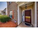 Close-up of the front door with brick facade, shutters and a welcoming 'Hey Friends' sign at 10071 Highland Creek Cir, Indian Land, SC 29707