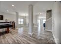 Spacious living room with grey wood flooring, large windows, and modern columns at 10071 Highland Creek Cir, Indian Land, SC 29707
