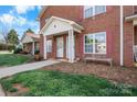 Brick townhome exterior with a covered front entrance, white columns, and well-manicured lawn at 102 Brandywine Ne Dr # R3, Conover, NC 28613