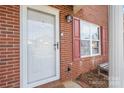 Up-close view of the front door, window with red shutters, and small front yard at 102 Brandywine Ne Dr # R3, Conover, NC 28613