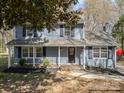 Charming blue two-story home with black shutters, covered porch, and mature landscaping at 1024 Eaglewood Ave, Charlotte, NC 28212