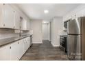 Bright kitchen with white cabinets, stainless steel appliances, subway tile backsplash, and wood-look flooring at 1024 Eaglewood Ave, Charlotte, NC 28212