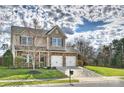 Charming two-story home featuring stone accents, a two-car garage, and a well-kept lawn at 12889 Clydesdale Dr # 59, Midland, NC 28107