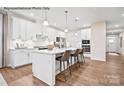 Modern kitchen features a central island with barstool seating, stainless appliances, and white cabinets at 2016 Bramble Hedge Rd # 3277, Indian Trail, NC 28079