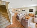 Bright living room featuring modern furnishings, hardwood floors, and an adjacent staircase at 217 Century Dr, Salisbury, NC 28147