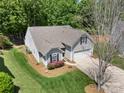 An aerial view showcases the home, its well-maintained lawn, and colorful flower beds at 4323 Wiregrass Rd, Indian Land, SC 29707