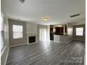 Open living room with fireplace, seamlessly connected to the modern kitchen area at 5011 Abercromby St, Charlotte, NC 28213