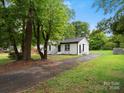View of home exterior, surrounded by mature trees and a long driveway at 5316 Rupert Ln, Charlotte, NC 28215