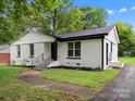 Side view of updated white brick home, with black trim and landscaped yard at 5316 Rupert Ln, Charlotte, NC 28215