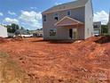 Backyard view of a two-story house with gray siding and an unfinished lawn at 5704 Skinny Dr, Charlotte, NC 28215