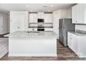 Modern kitchen with white cabinets, stainless steel appliances, and a large island at 5704 Skinny Dr, Charlotte, NC 28215