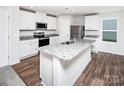 Bright kitchen featuring white cabinets, stainless steel appliances, granite countertops, and a kitchen island at 5715 Skinny Dr, Charlotte, NC 28215