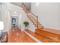 Bright foyer with wooden staircase and floors leading to the main living areas at 615 Vega Nw St, Concord, NC 28027