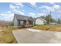 Exterior view of a quaint home showcasing a long driveway and well-maintained front yard at 619 N Skyland Dr, Mount Pleasant, NC 28124