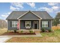 Attractive single-story home featuring a welcoming front porch, American flag, and neat landscaping at 619 N Skyland Dr, Mount Pleasant, NC 28124