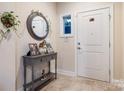 Warm and inviting foyer with a decorative table, mirror, and tiled flooring at 7909 Parknoll Dr, Huntersville, NC 28078