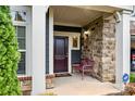 Inviting front porch with a stone facade, bench, and an ADT security system sign for added peace of mind at 7909 Parknoll Dr, Huntersville, NC 28078