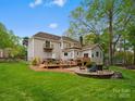 Spacious backyard with multiple decks, a fire pit, and lush greenery, ideal for outdoor entertaining at 9009 Stourbridge Dr, Huntersville, NC 28078