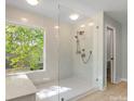 Spacious bathroom featuring a large, glass-enclosed shower and a window offering a scenic outdoor view at 9009 Stourbridge Dr, Huntersville, NC 28078