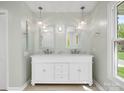 Bathroom featuring a double vanity with modern fixtures, stylish lighting, and a bright window at 9009 Stourbridge Dr, Huntersville, NC 28078