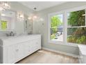 Bright bathroom featuring a double vanity, pendant lights, and a large window providing natural light and outdoor views at 9009 Stourbridge Dr, Huntersville, NC 28078