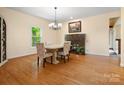 Cozy dining area featuring hardwood floors, a chandelier, and a charming fireplace, creating an inviting space at 9009 Stourbridge Dr, Huntersville, NC 28078