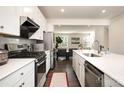 Stylish kitchen with stainless appliances, gas range, white cabinets and an adjacent living area at 108 Helm Ln, Mooresville, NC 28117