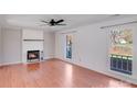 Bright living room with a fireplace, laminate floors, and natural light from two windows at 13732 Strathaven Dr, Matthews, NC 28105