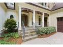 Charming front porch with stone steps, decorative columns, and a well-maintained garden at 147 Pearl Bay Dr, New London, NC 28127