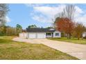 This home features a two-car garage, a large driveway, and a storage building at 155 Country Ln, Mooresville, NC 28115