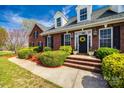 Charming brick home entrance with manicured bushes, black shutters, and a welcoming wreath on the door at 1790 Faires Rd, Rock Hill, SC 29730