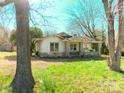 Single story home with stone accents and covered porch, framed by mature trees and a green lawn at 2033 Shelby Rd, Kings Mountain, NC 28086