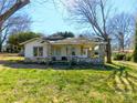 Cozy home featuring a covered porch with stone supports and a well-maintained lawn at 2033 Shelby Rd, Kings Mountain, NC 28086