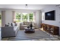 Cozy living room with comfortable sofas, a striped rug, and a large window overlooking the yard at 2117 Moss Bluff Dr, Mint Hill, NC 28227