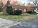 Quaint brick house featuring a well-manicured lawn, an inviting front porch and an attached chimney at 213 Crowell Ave, Albemarle, NC 28001