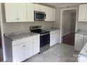 A well-lit kitchen with modern white cabinets, stainless steel appliances, and granite countertops at 213 Crowell Ave, Albemarle, NC 28001