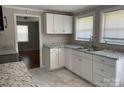 Updated kitchen with white cabinets, granite countertops, and stainless steel sink under a bright window at 213 Crowell Ave, Albemarle, NC 28001