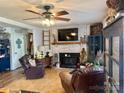 Comfortable living room showcases brick fireplace with TV, wood floors, and cozy recliner at 25924 Millingport Rd, Albemarle, NC 28001