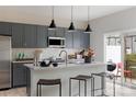 Modern kitchen with grey cabinets, stainless appliances, island seating, and a sliding door to the patio at 3012 Hutton Gardens Ln, Charlotte, NC 28269