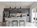 Modern kitchen with gray cabinetry, stainless steel appliances, a white island, and barstool seating at 3012 Hutton Gardens Ln, Charlotte, NC 28269