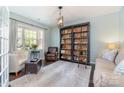 Inviting living room with custom bookshelf, stylish seating, and a bright window that enhances the room's charm at 3034 Oakmere Rd, Waxhaw, NC 28173