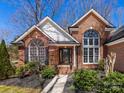 Charming brick home with manicured landscaping, large windows, and a welcoming entrance on a sunny day at 3222 Shadow Lake Ln, Matthews, NC 28104