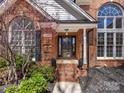 Close-up of the home's front entrance, highlighting the brick facade, steps and decorative plants at 3222 Shadow Lake Ln, Matthews, NC 28104